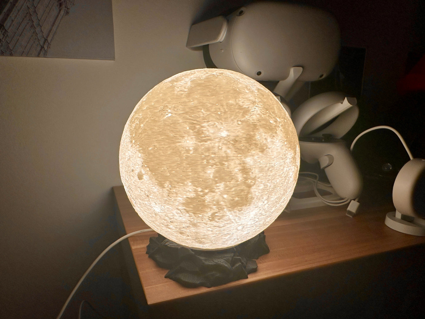 Lampe in Mond Optik auf schwarzen Sockel in Felsen Optik
