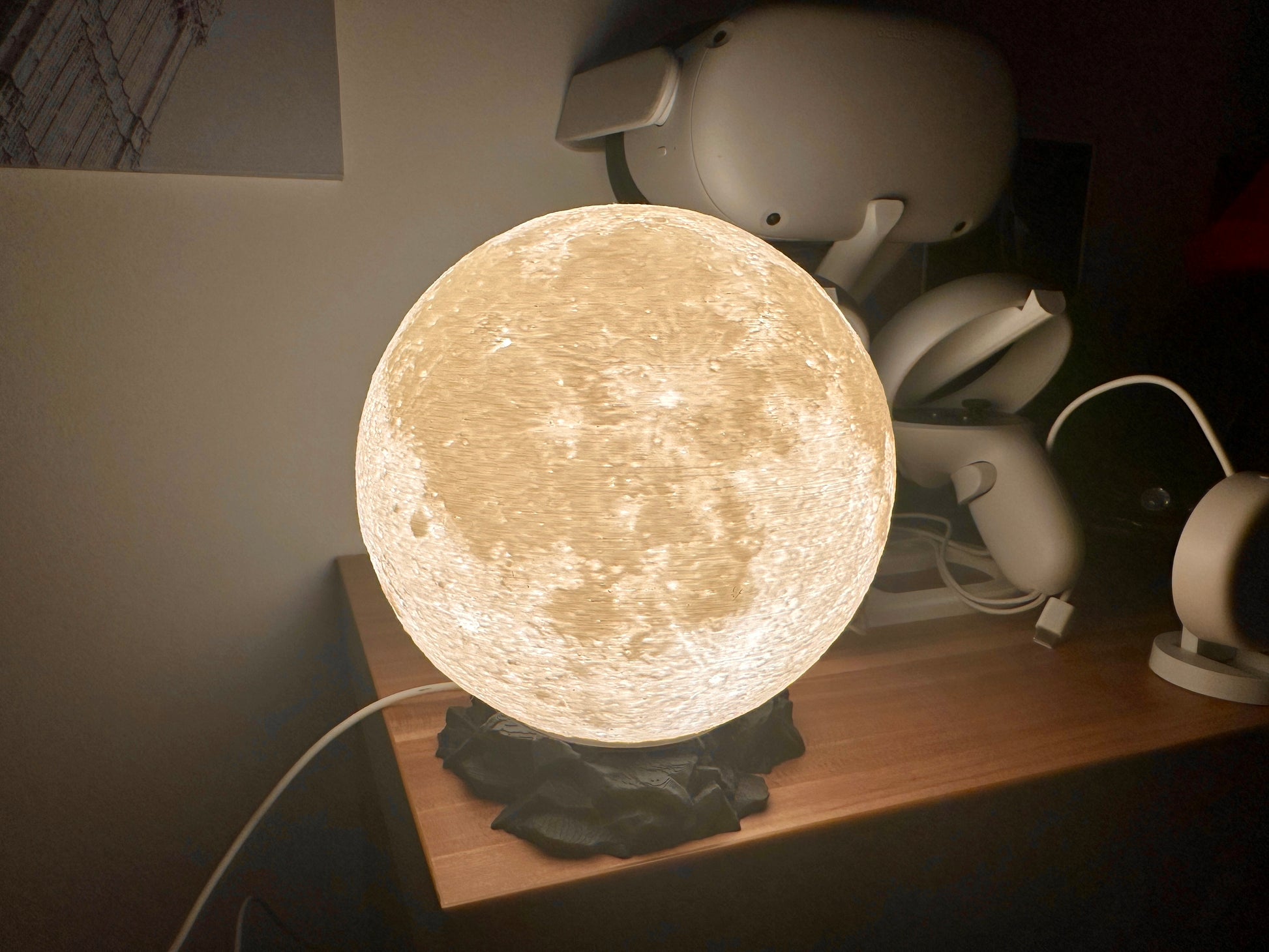 Lampe in Mond Optik auf schwarzen Sockel in Felsen Optik